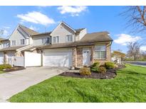 Charming townhome with attached garage, brick accents, lush lawn, and welcoming curb appeal at 9442 Avon Strand # D, Avon, IN 46123