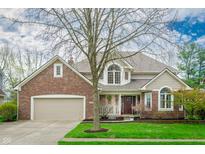 Charming two-story brick home featuring a manicured front lawn and attached two car garage at 12507 Doe Ln, Indianapolis, IN 46236