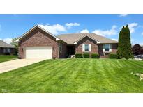 Charming brick home featuring a manicured lawn, attached garage, and neat landscaping, perfect for suburban living at 300 Kathryn Ct, Clayton, IN 46118