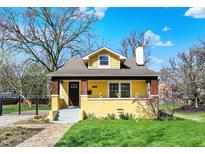 Charming yellow home with a dormer window, quaint front porch and well-maintained lawn at 3484 Birchwood Ave, Indianapolis, IN 46205