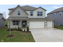Charming two-story home boasts a two-car garage and meticulously landscaped front yard at 4831 E Oak Hill E Dr, Lebanon, IN 46052