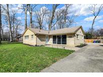 Well-maintained home with a green lawn, mature trees, and a paved driveway leading to the property at 500 N Shellbark Rd, Muncie, IN 47304