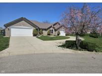 Charming brick home with a well-manicured lawn and a circular driveway at 52 Spring Lake Ct, Trafalgar, IN 46181