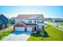 Inviting two-story home with a well-manicured lawn and three-car garage at 5839 Altar Bell Cir, Greenwood, IN 46143