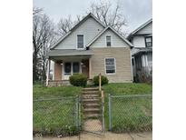 Modest two-story home featuring tan brickwork and a small front porch at 630 Congress Ave, Indianapolis, IN 46208