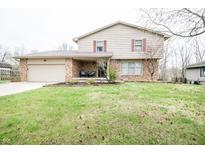 Charming two-story home with a brick facade, inviting front porch, and attached garage at 632 Ridgeview Ln, Columbus, IN 47201
