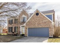 Charming two-story brick home with attached gray garage and well-maintained front yard at 8415 Anchorage Ct, Indianapolis, IN 46236