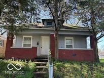 Charming single-story home with a covered porch and mature trees at 867 W 25Th St, Indianapolis, IN 46208