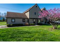 Charming townhome featuring mature landscaping and flowering tree in the front yard at 9609 Highgate N Cir, Indianapolis, IN 46250