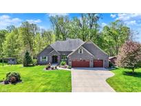 Beautiful brick home featuring a three-car garage and a well-manicured lawn at 9879 Ruby Ct, Mooresville, IN 46158