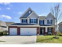 Charming two-story home with a manicured lawn, a brick and vinyl facade, and a three-car garage at 1291 Timber Bluff Rd, Westfield, IN 46074