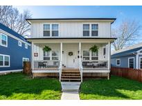 Charming two-story home with a inviting front porch, fresh green lawn, and beautiful curb appeal at 1603 E Market St, Indianapolis, IN 46201