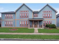 Charming blue townhouse with red trim, inviting front porch, and well-maintained lawn at 1635 N College Ave # 5, Indianapolis, IN 46202