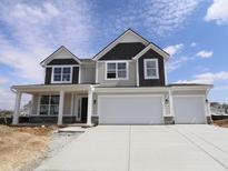 New two-story home showcasing a two-car garage, neutral siding, and a charming front porch at 17026 Cowbell Dr, Noblesville, IN 46060