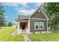 Charming two-story home featuring gray siding, well-manicured lawn, and inviting front porch at 1838 Applegate St, Indianapolis, IN 46203