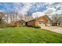 Charming brick home featuring an attached three car garage, well-manicured lawn, and mature trees at 206 Somerville Rd, Anderson, IN 46011