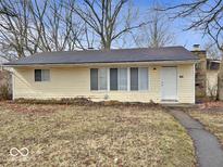 Charming single-story home with a yellow exterior, a well-maintained lawn, and a welcoming front door at 2260 N Graham Ave, Indianapolis, IN 46218
