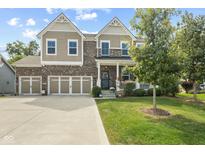 Charming two-story home with a three car garage, brick accents, covered porch, and manicured lawn at 4285 Nottinghill Dr, Avon, IN 46123