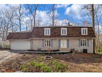 Charming stone home featuring a unique roof and a spacious two-car garage at 5917 Camelback Ct, Indianapolis, IN 46250