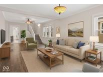 Bright living room with hardwood floors, a neutral color palette, and a staircase at 601 Wallace Ave, Indianapolis, IN 46201