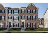Charming townhome with brick and siding, featuring black shutters and well-manicured landscaping at 6953 Equality Blvd, Carmel, IN 46033