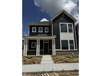 New construction two-story home with a welcoming front porch, dark siding, and large windows under a sunny, cloudy sky at 798 James William Ln, Westfield, IN 46074