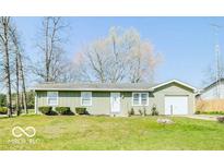 Charming single story home featuring an attached garage and a well-maintained front lawn at 12566 S Hillview Dr, Columbus, IN 47201