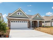 Charming brick home featuring a two-car garage and covered porch, set under a bright blue sky at 19245 Red Willow Ln, Noblesville, IN 46062