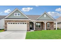 Charming brick home with a two-car garage, green lawn, and stylish front porch at 19245 Red Willow Ln, Noblesville, IN 46062