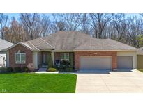 Beautiful brick home with a well-manicured lawn, attached garage, and a charming front porch at 267 Westbrook Ct, Columbus, IN 47201