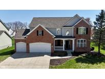 Beautiful two-story home featuring a brick facade, attached two-car garage, and well-manicured lawn at 5145 Greenheart Pl, Indianapolis, IN 46237