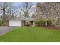 Charming single-story brick home with a well-manicured lawn and mature trees at 7026 Spring Mill Rd, Indianapolis, IN 46260