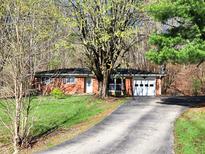 Charming brick ranch home with an attached two-car garage surrounded by lush trees at 7132 N Stafford Ln, Martinsville, IN 46151