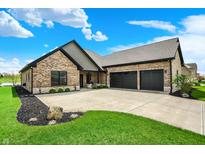 Beautiful brick home with an attached three-car garage and a large driveway and professionally landscaped yard at 725 Meadowbrook Ln, Franklin, IN 46131