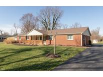 Charming brick home with a covered front porch and well-maintained lawn at 7260 Marla Dr, Indianapolis, IN 46256