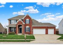 Charming two-story brick home featuring a three-car garage, blue shutters, and a well-manicured lawn at 8734 Blue Marlin Dr, Indianapolis, IN 46239