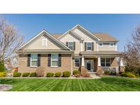 Charming two-story home featuring a brick facade, complemented by a well-manicured lawn and established landscaping at 8855 Sugar Cay Ct, Zionsville, IN 46077