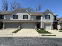 Three-unit townhouse featuring attached garages, neutral siding and brick facade, and well-maintained lawns at 1012 S Montgomery Rd, Greenwood, IN 46143