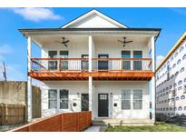 A modern duplex featuring white siding, black trim, and double balconies, creating a stylish and inviting facade at 1018 Calvary St, Indianapolis, IN 46203