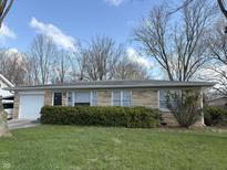 Charming single-story home with stone facade, manicured lawn, and attached garage, perfect for comfortable suburban living at 1018 E 106Th St, Indianapolis, IN 46280