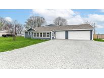 Charming home featuring a gravel driveway and attached two-car garage, perfect for suburban living at 1254 E 400 N, Greenfield, IN 46140