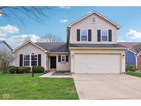 Charming two-story home featuring a two car garage, well maintained lawn and dark shutters against neutral siding at 13847 Wabash Dr, Fishers, IN 46038