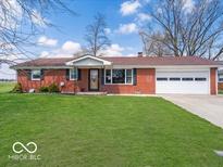 Charming single-story brick home featuring a well-manicured lawn and an attached garage at 1734 Bittersweet Dr, Anderson, IN 46011