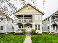 Charming yellow two-story home featuring double porches and a well-manicured lawn at 2316 N Pennsylvania St # 1, Indianapolis, IN 46205