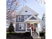 Charming two-story home featuring stylish gray siding, a bright red door, and a welcoming front porch with white railings at 2419 N Park Ave, Indianapolis, IN 46205