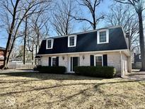 Charming brick home featuring a well-manicured lawn and mature trees at 2605 W Berkshire Dr, Muncie, IN 47304