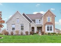 Beautiful two-story home with stone and brick facade, lush lawn, and well-maintained landscaping at 3665 Conifer Dr, Zionsville, IN 46077