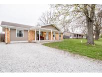 Charming single-story home featuring a covered front porch, brick accents, and a gravel driveway at 504 W Dwain, Shelbyville, IN 46176