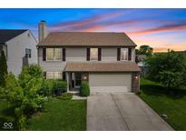 Charming two-story home featuring a two-car garage and a well-manicured lawn at 518 Carthage Cir, Westfield, IN 46074
