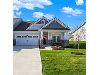 Charming one-story home with a well-manicured lawn, tidy landscaping and a cozy front porch seating area at 6625 Ferguson Dr, Whitestown, IN 46075